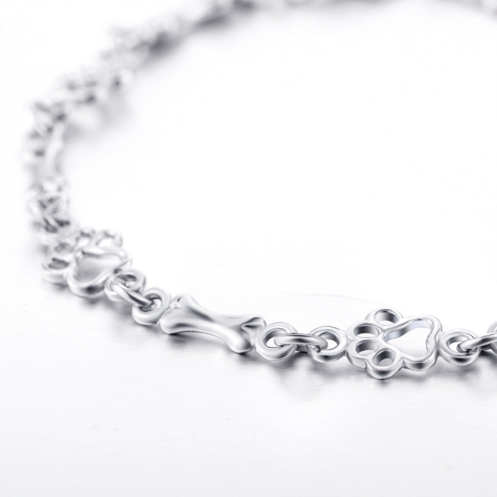 Pulsera de plata con dije de pata de perro y hueso