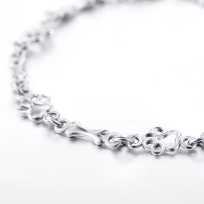 Pulsera de plata con dije de pata de perro y hueso